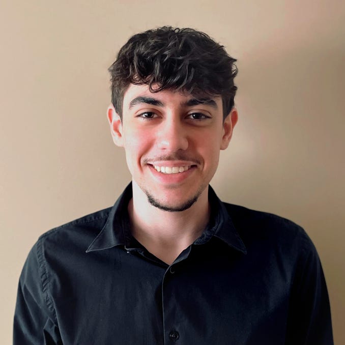 Groupe de jeunes adultes étudiant ensemble dans une bibliothèque, tenant des livres.